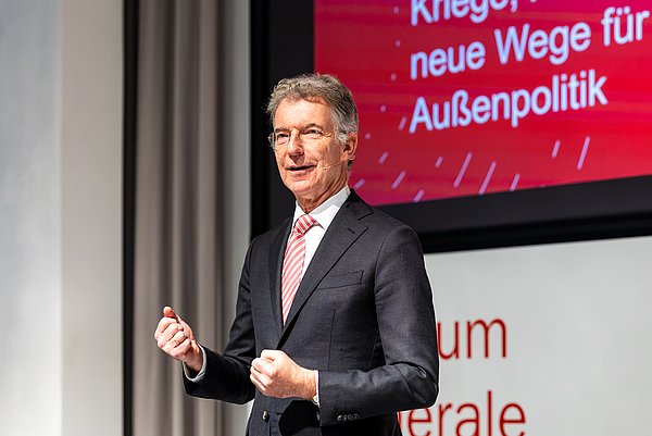 4 Menschen, davon zwei Frauen (Organisatorinnen des Studium Generale) sowie zwei Männer (Hochschulrektor und Vortragender Christoph Heusgen) lächeln in die Kamera.