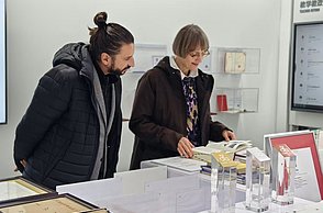 Die Visiting Professors aus Pforzheim in Changsha: Prof. Cosima Striepe und Stefan Barth blättern in hochschuleigenen Publikationen.