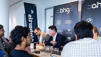 Personen im Austausch an einem Tisch