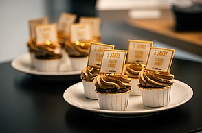 Foto von zwei Tellern auf welchen jeweils 4 kleine Cupcakes stehen.