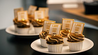 Foto von zwei Tellern auf welchen jeweils 4 kleine Cupcakes stehen.