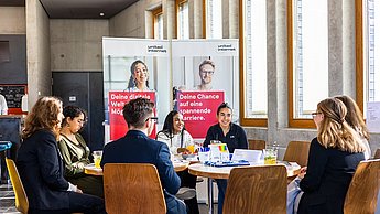 Studierende und Unternehmensvertreter an einem Tisch
