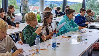 Kinder in einer Reihe hören interessiert zu