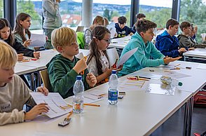 Kinder in einer Reihe hören interessiert zu