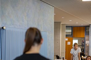 Eine Studentin erklärt den Kindern am Rennsimulator worauf es ankommt
