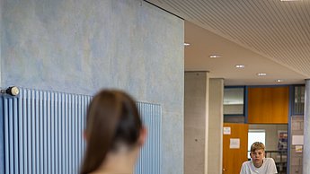Eine Studentin erklärt den Kindern am Rennsimulator worauf es ankommt
