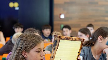 Kinder schauen sich Bienenwaben und Utensilien zur Imkerei an.