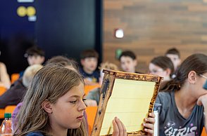 Kinder schauen sich Bienenwaben und Utensilien zur Imkerei an.