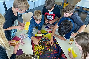 Kinder kleben mit Punkten Bilder von Einstein und Marie Curie