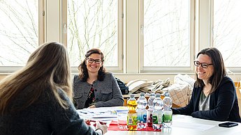 Zwei Mitarbeiterinnen der Firma Witzenmann am Tisch mit einer Studentin