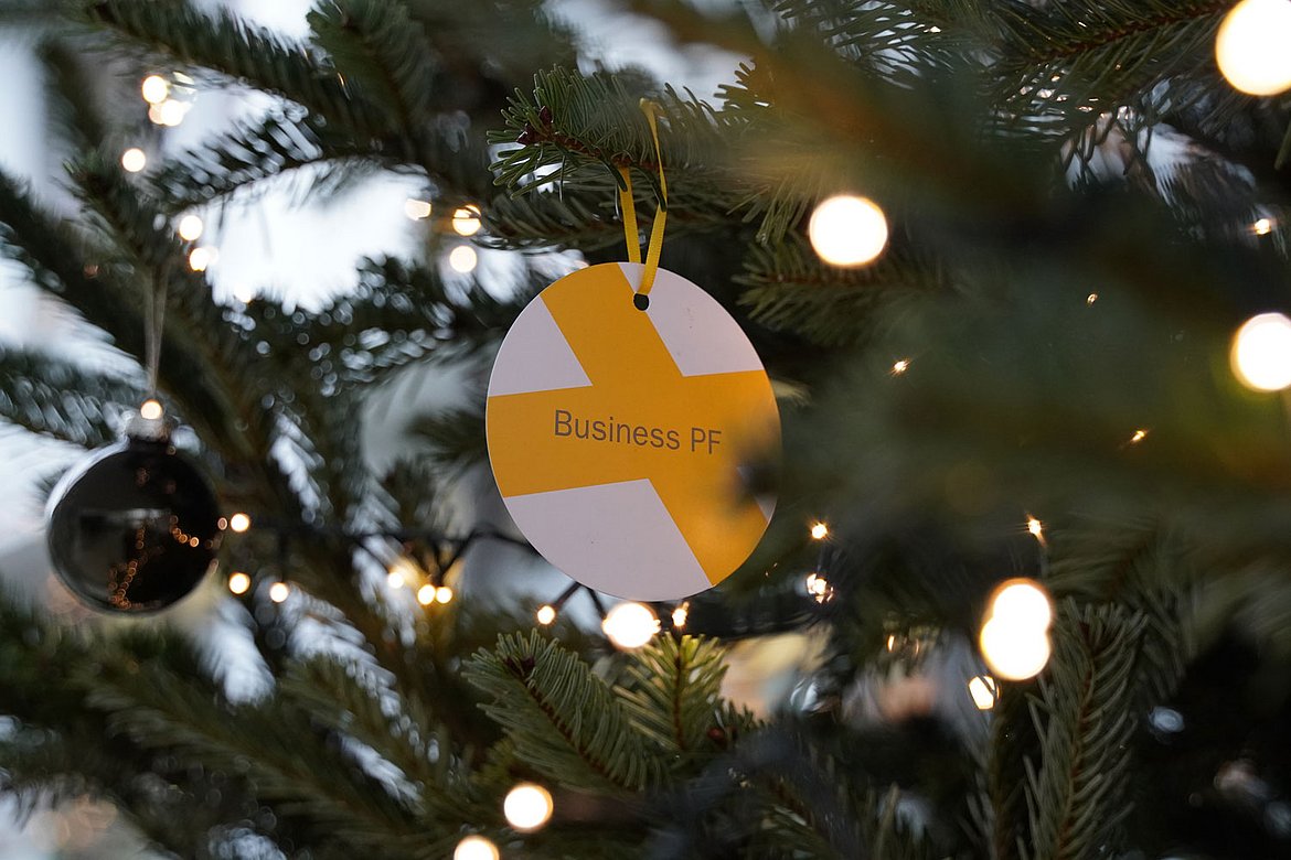 Ein Anhänger mit der Aufschrift Business PF hängt am Weihnachtsbaum an der Business School