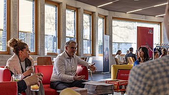 Ein Mann unterhält sich und sitzt auf einem Sofa