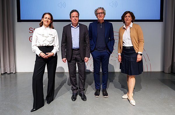 2 Frauen (Organisatorinnen des Studium Generale), sowie zwei Herren (Rektor der Hochschule und der Referent) lächeln in die Kamera.