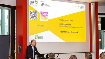 Ein Professor begrüßt die Besucher.