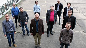 Erste Reihe: Christoph Lehnert (HS Pforzheim), Thomas Greiner (HS Pforzheim), Grischan Engel (HS Pforzheim) (von links nach rechts). Zweite Reihe: Torben Sölken (Logi.cals GmbH), Thomas Kuhn (Fraunhofer-Institut für Experimentelles Software Engineering), Wolfgang Heich (GS Kunststofftechnik - Gebrüder Schmidt KG) (von links nach rechts). Dritte Reihe: Dieter Goltz (Logi.cals GmbH), Thomas Psota (Fraunhofer-Institut für Experimentelles Software Engineering), Markus Lehr (VSR Elektrotechnik GmbH), Rainer Drath (HS Pforzheim) (von links nach rechts). (Foto: Sophia Zundel/Hochschule Pforzheim)