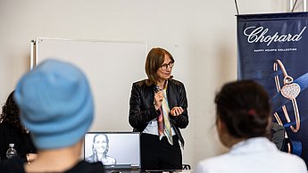 Vertreterin der Firma Chopard erklärt Studierenden etwas und steht vor der Gruppe
