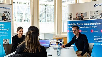 Mitarbeiter der Firma Witzenmann im Gespräch mit einer Studentin