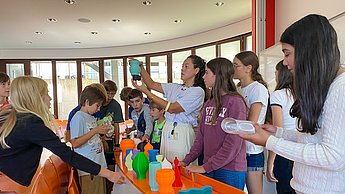 Kindergruppe schaut sich Lampenschirme aus dem 3D Druck an