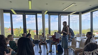 Kinder sitzen im Stuhlkreis und spielen Werwolf