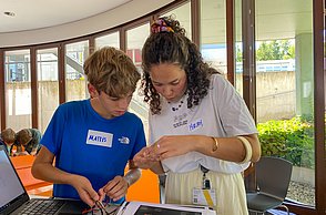 Workshopleiterin und Junge arbeiten am Laptop