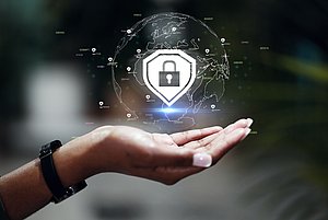 Foto einer Hand, darüber schwebt ein Schloss und dahinter sieht man eine Abbildung für Internet. Symbolbil für Datenschutz.