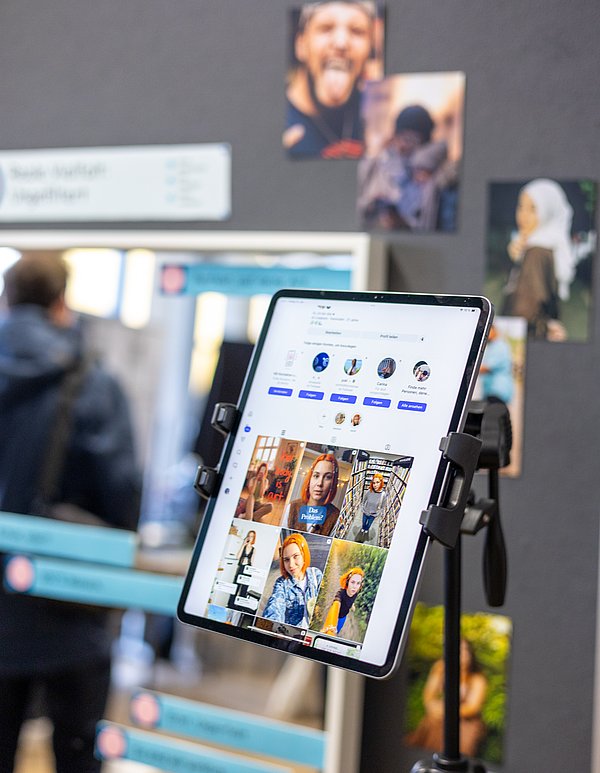 Ein Tablet zeigt das Profil der KI-Erstellten Influencerin Aila Veto. Diese haben zwei Studentinnen innerhalb eines Projekts erstellt.