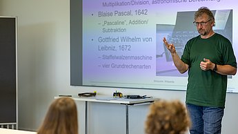 Workshopleiter zeigt eine Lösung vorne am Flipchart