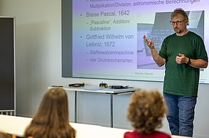 Workshopleiter zeigt eine Lösung vorne am Flipchart