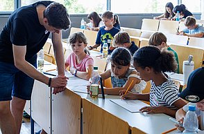 Kinder mit Studenten im Austausch.