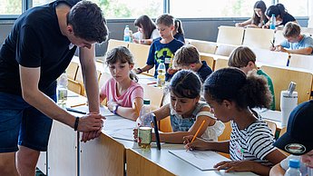 Kinder mit Studenten im Austausch.