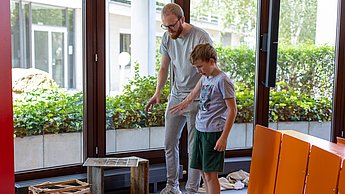 Kinder bauen eine Bienenbeute auf.