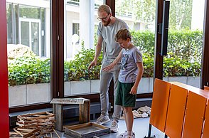 Kinder bauen eine Bienenbeute auf.