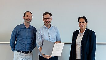 Professor, Gewinner und Moderatorin während der Verleihung.