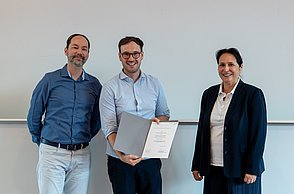 Professor, Gewinner und Moderatorin während der Verleihung.