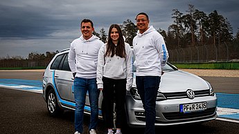 Vertreter der Firma Rutronik auf der Rennstrecke vor Ihrem Auto