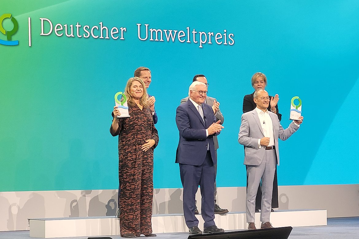Sechs Personen auf der Bühne bei der Verleihung des Deutschen Umweltpreises, in der vorderen Reihe Dr. Roda Verheyen, Bundespräsident Frank-Walter Steinmeier, Dr. Klaus Vossenkaul