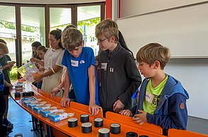 Kindergruppe schaut sich Lampenschirme aus dem 3D Druck an