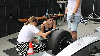 Studierende beim Reifenwechsel