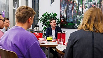 Ein Mitarbeiter der Firma BDO im Gespräch mit Studierenden