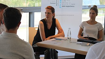 Personen an einem Tisch im Gespräch 