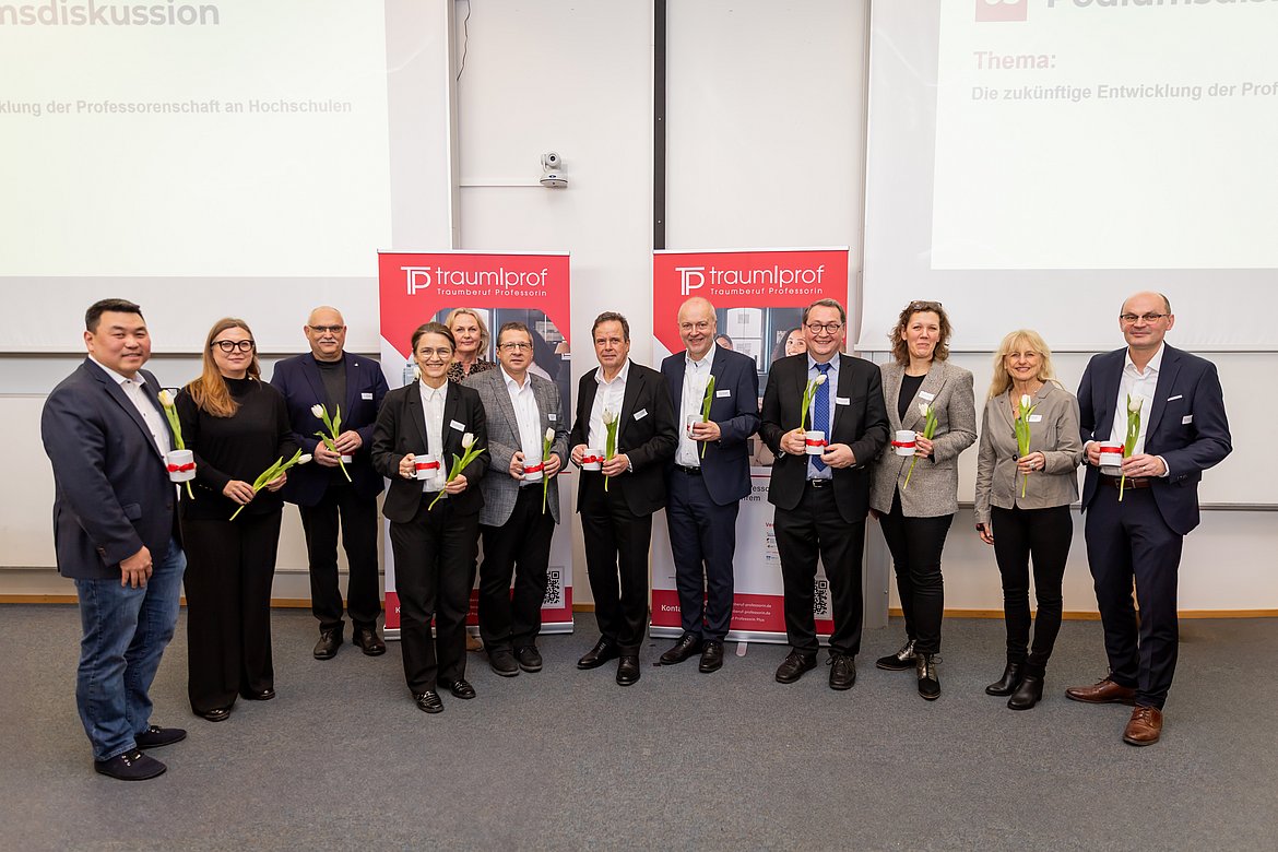  Gruppenfoto des Rektorenpodiums mit vielen Menschen, die in die Kamera lachen.