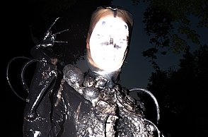 Person in schwarzem Kostüm posiert