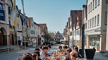 Menschen sitzen an einem langen Tisch