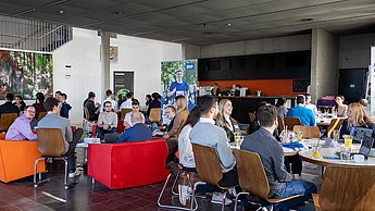 Verschiedene Sitzgruppen mit Studierenden und Firmenvertretern