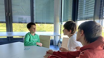 Kinder disskutieren in der Gruppe die Ergebnisse zum Thema Treibhaus-Kompass
