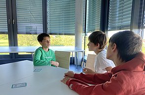 Kinder disskutieren in der Gruppe die Ergebnisse zum Thema Treibhaus-Kompass