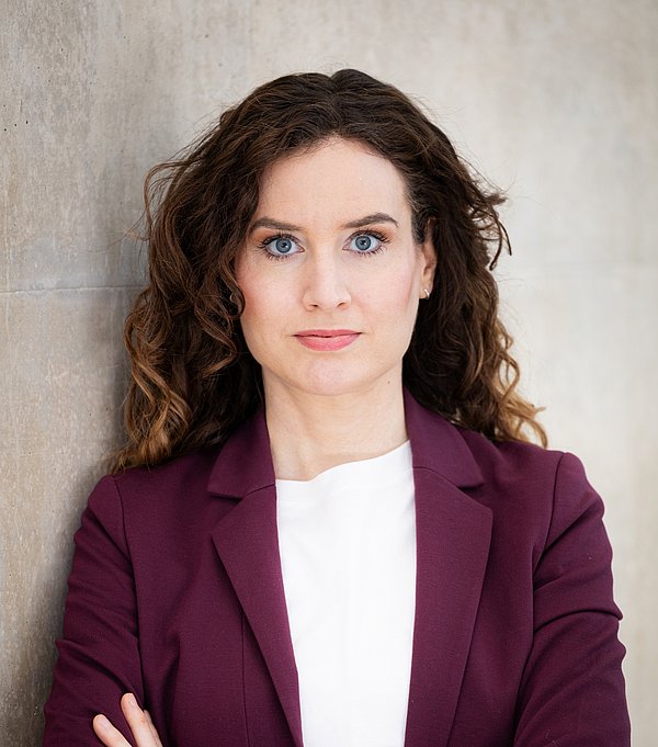 Frau mit Locken schaut in die Kamera