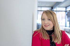 A woman leaning against a wall and smiling