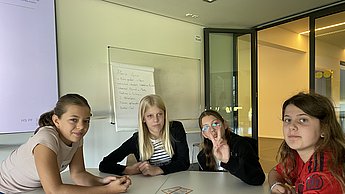 Kinder disskutieren in der Gruppe die Ergebnisse zum Thema Treibhaus-Kompass