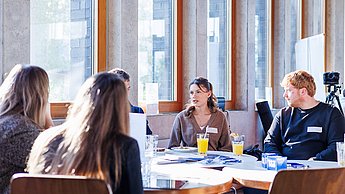Studierende und Unternehmen an einem Tisch